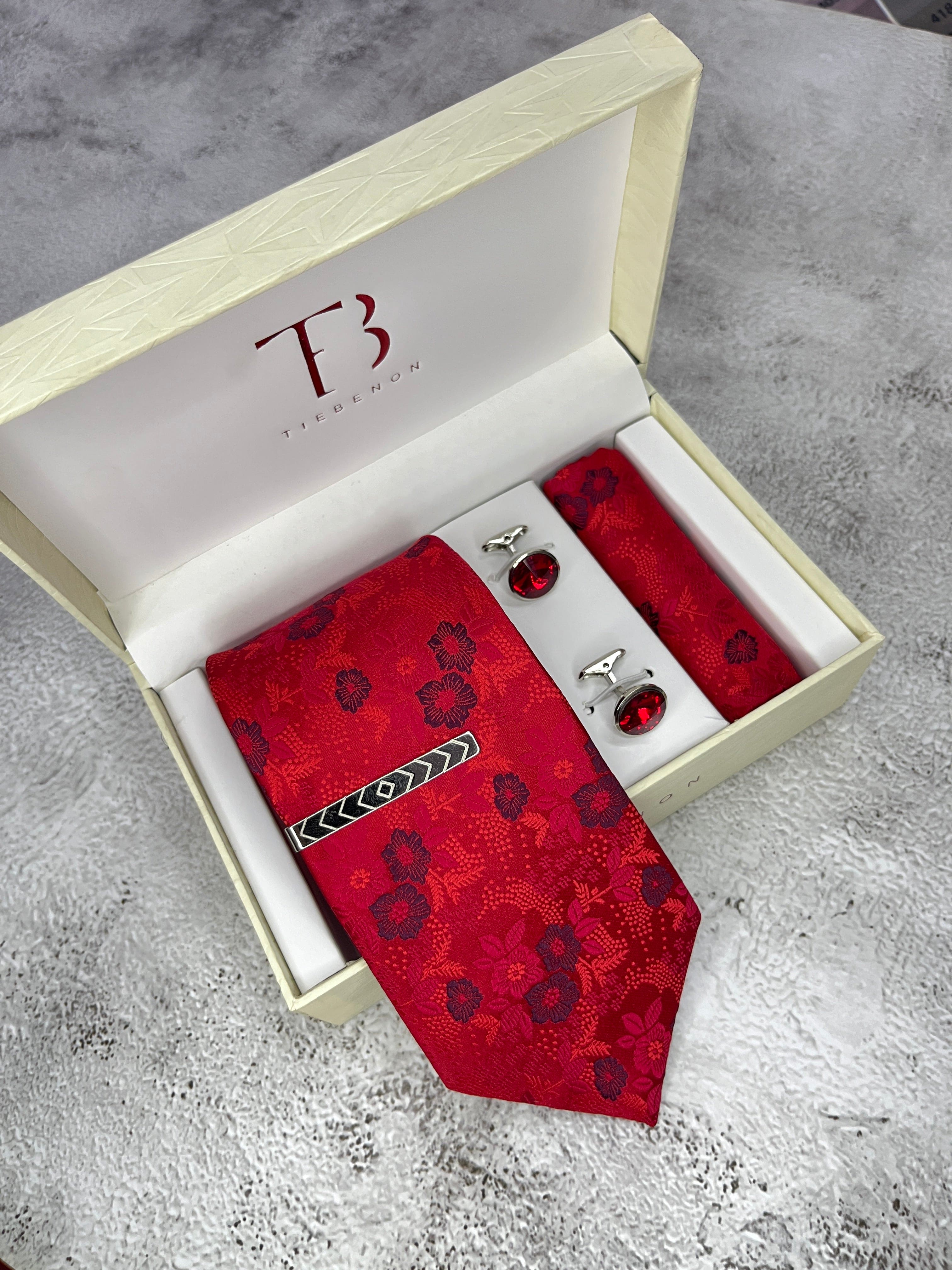 A red floral tie with a microsilk texture, displayed in an open white box with a branded 'T' on the top and a pair of dark red cufflinks.
