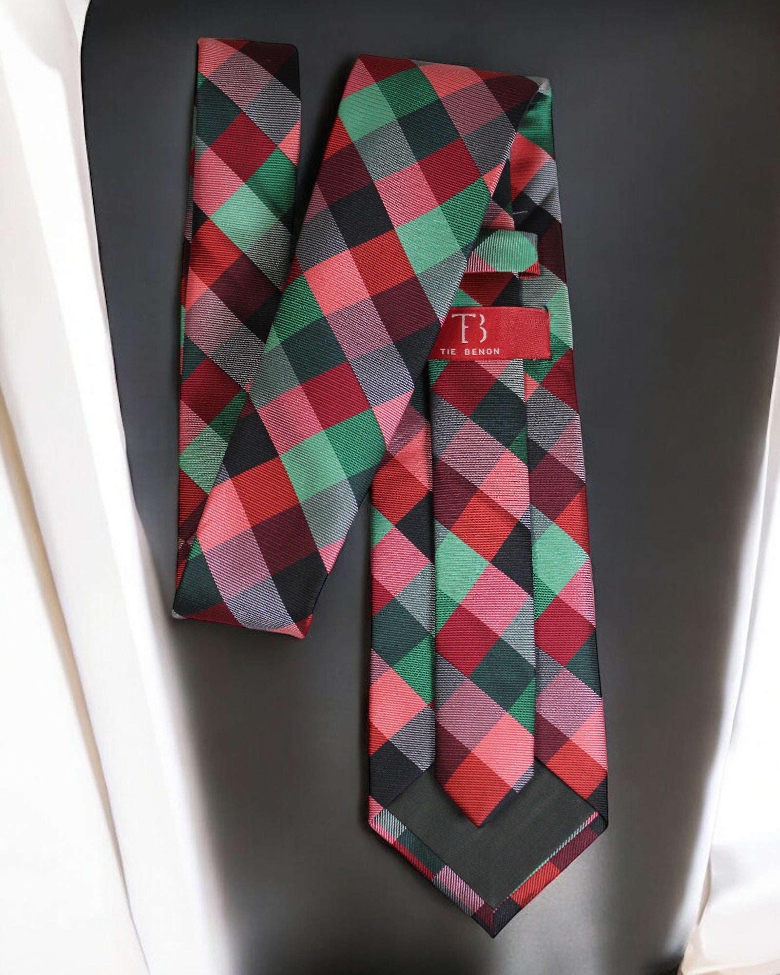Plaid tie with a red label on a dark surface Tie Benon