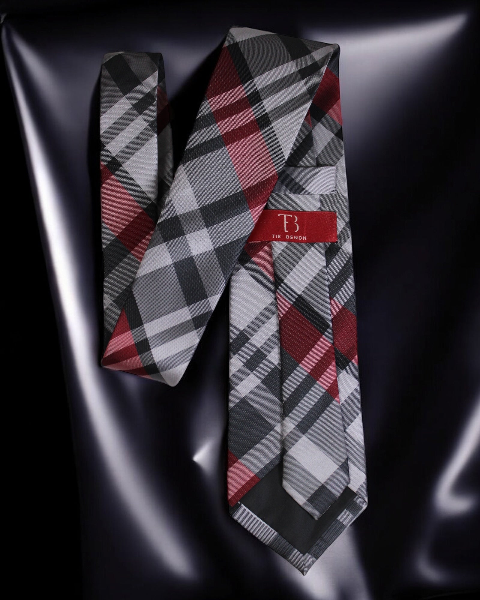 Plaid tie with a red label on a reflective black surface Tie Benon