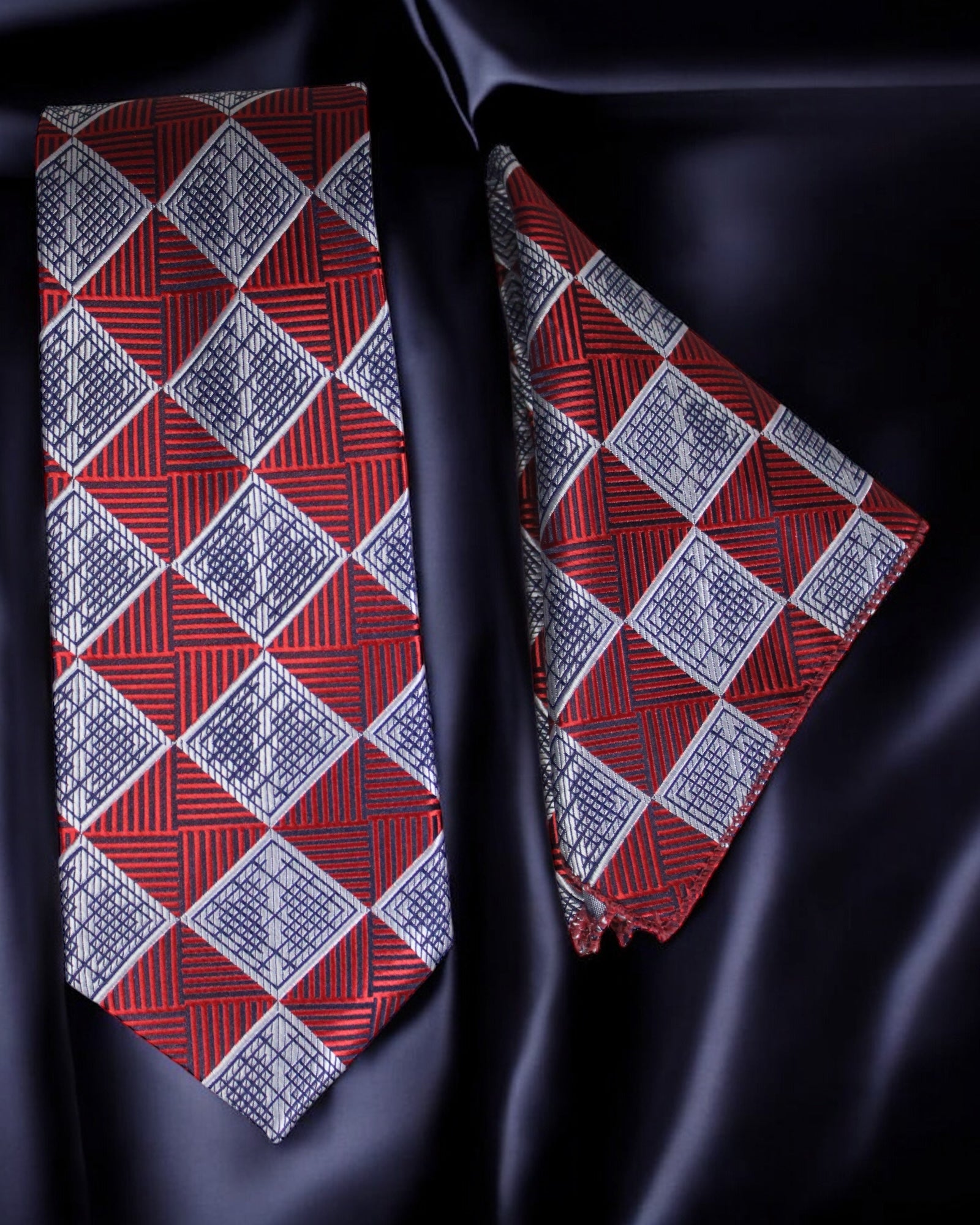 Red and blue patterned tie and pocket square on a dark fabric background Tie Benon