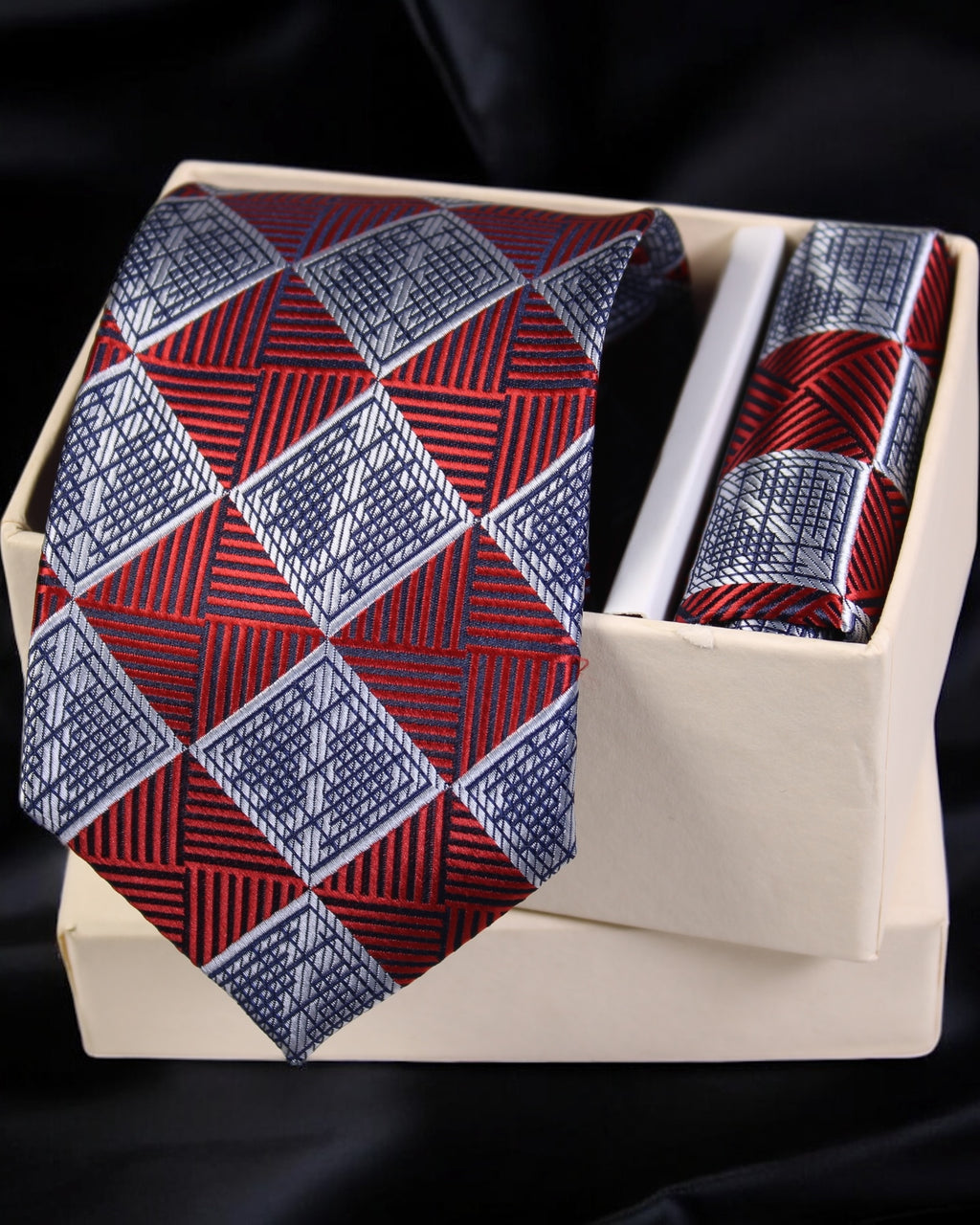 Red and blue patterned tie and pocket square set in a wooden box on a black background Tie Benon