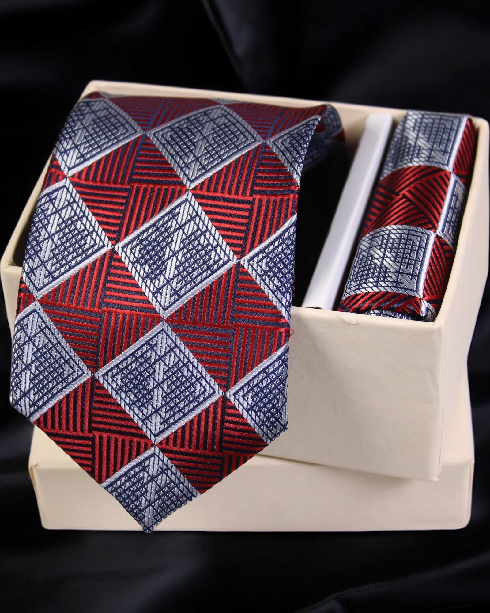 Red and blue patterned tie and pocket square set in a wooden box on a black background Tie Benon