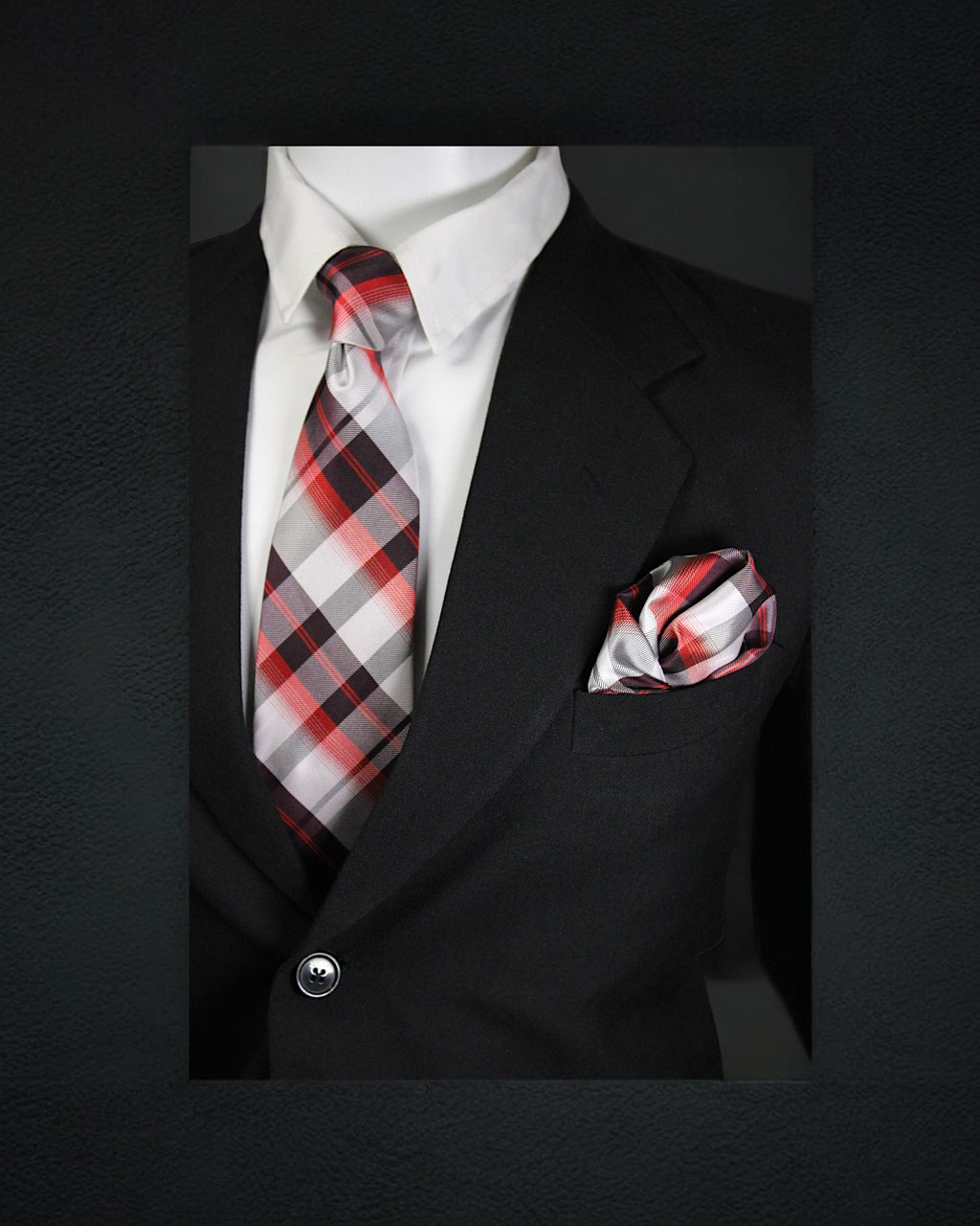 Black suit with a red and gray plaid tie and matching pocket square on a dark background tie Benon