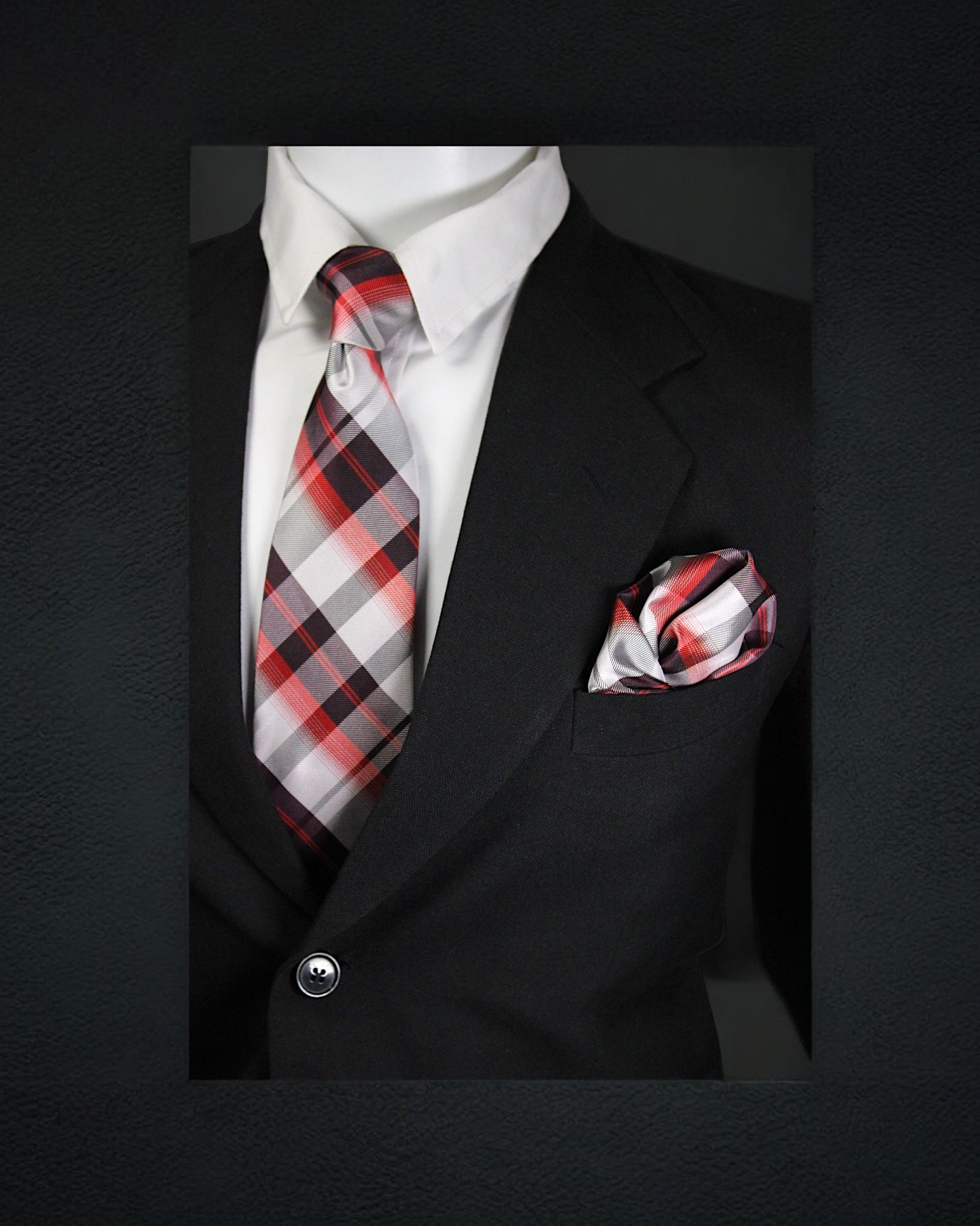 Black suit with a red and gray plaid tie and matching pocket square on a dark background tie Benon