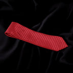 Red textured tie on black fabric background