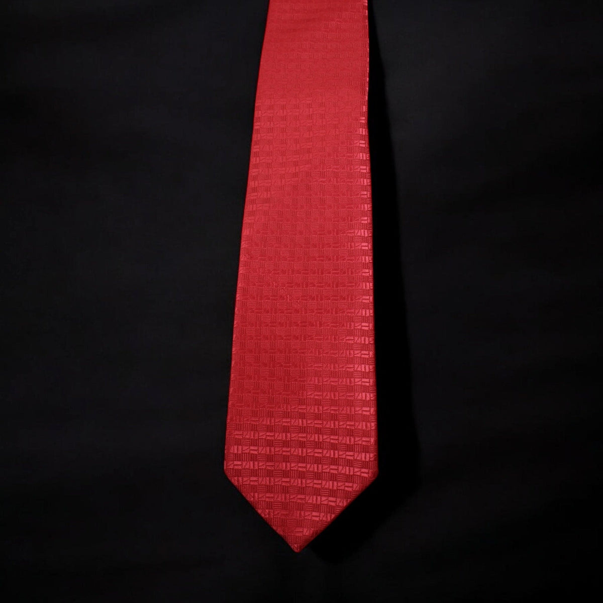 Red tie with a subtle pattern on a black background