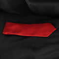 Red textured tie on a black fabric background