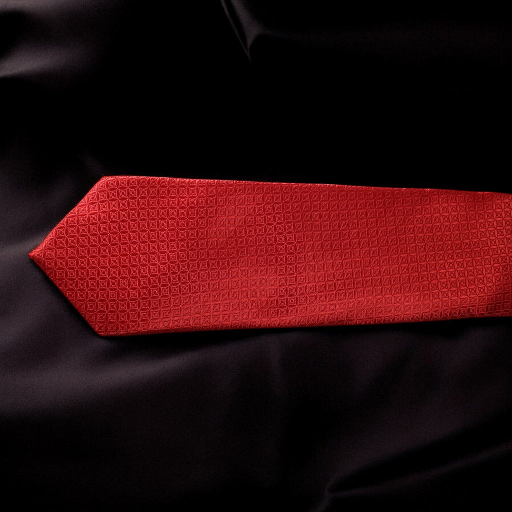 Red textured tie on a black fabric background
