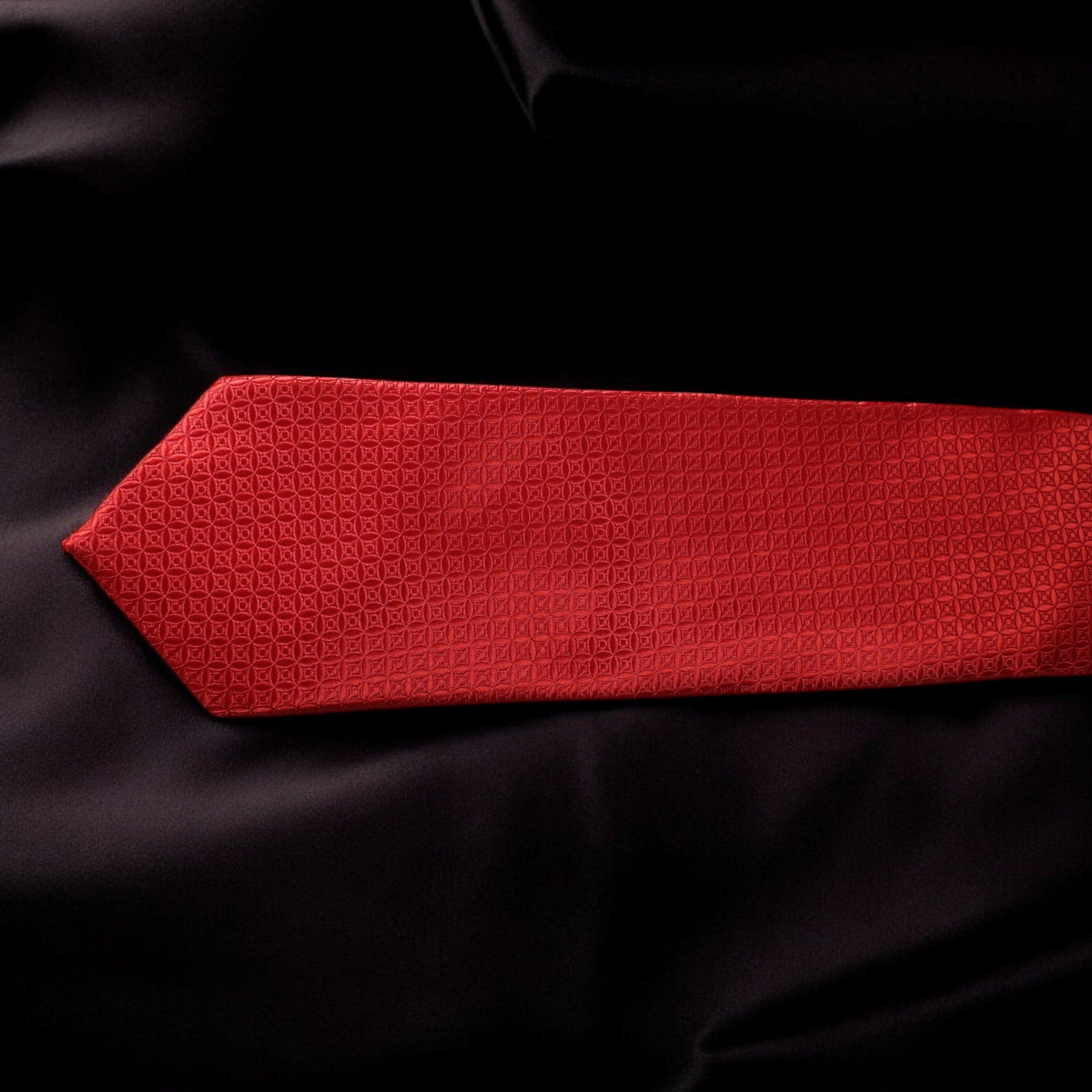 Red textured tie on a black fabric background