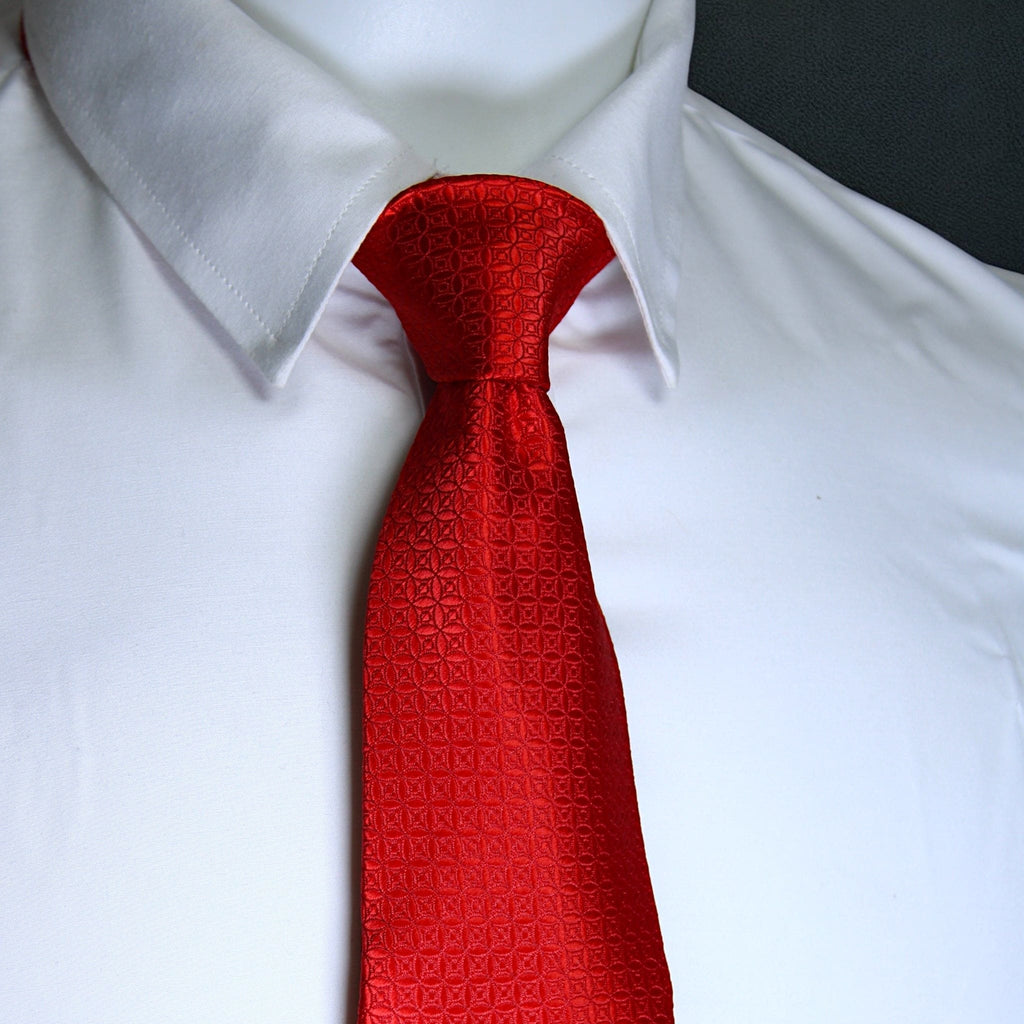 Red patterned tie on a white shirt with a blurred background