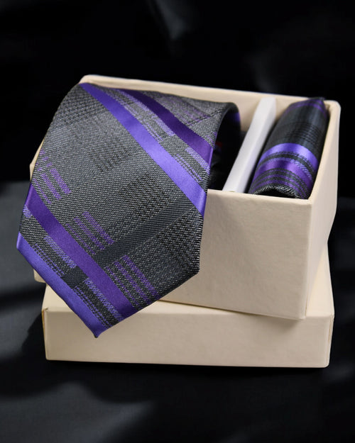 Black and purple striped tie in a beige box on a black background