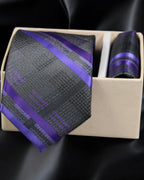 Purple and gray striped tie with matching pocket square in a box on a black background