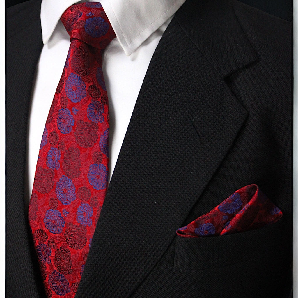 Red and blue patterned tie and pocket square with a black suit jacket.