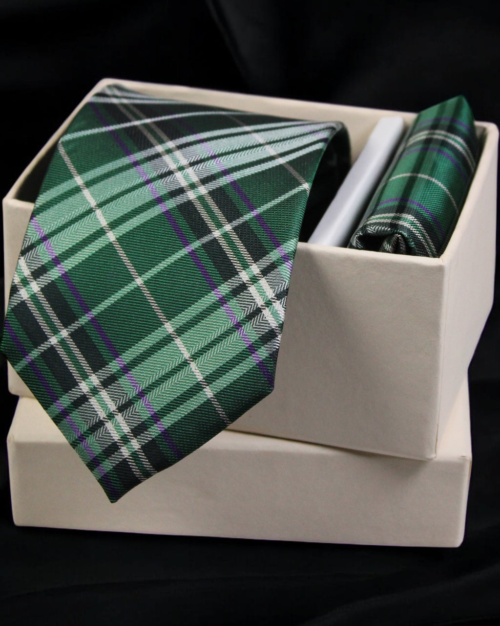 Green plaid tie and pocket square set in a white box on a black background