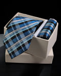 Blue plaid tie and pocket square set in a white box on a black background