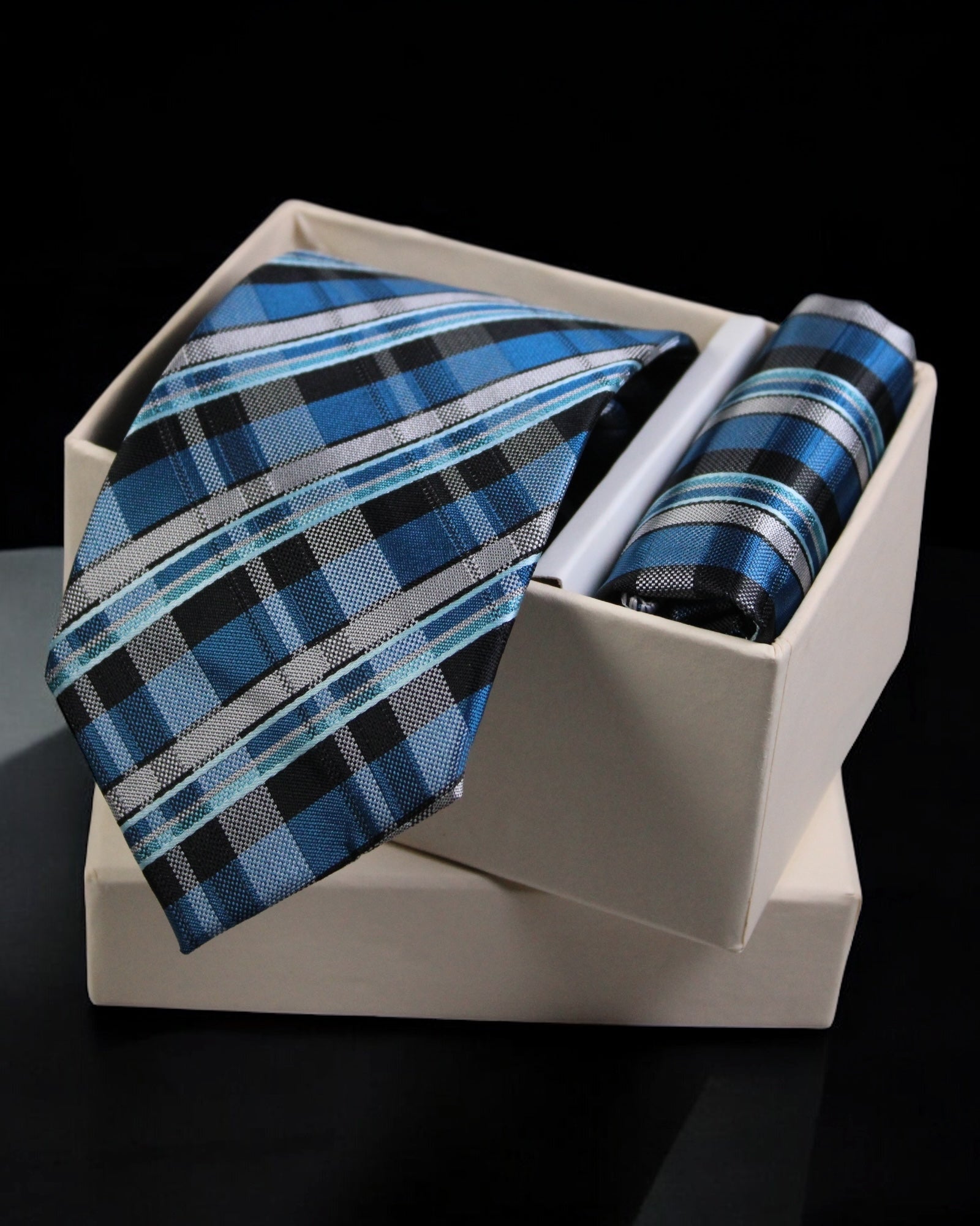 Blue plaid tie and pocket square set in a white box on a black background