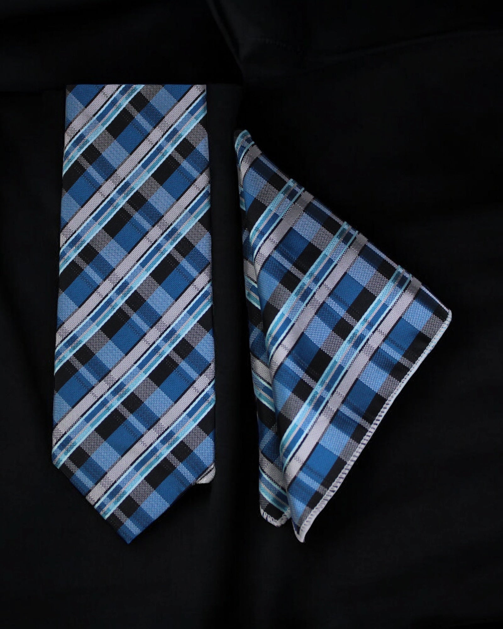 Blue plaid tie and pocket square set on a black background