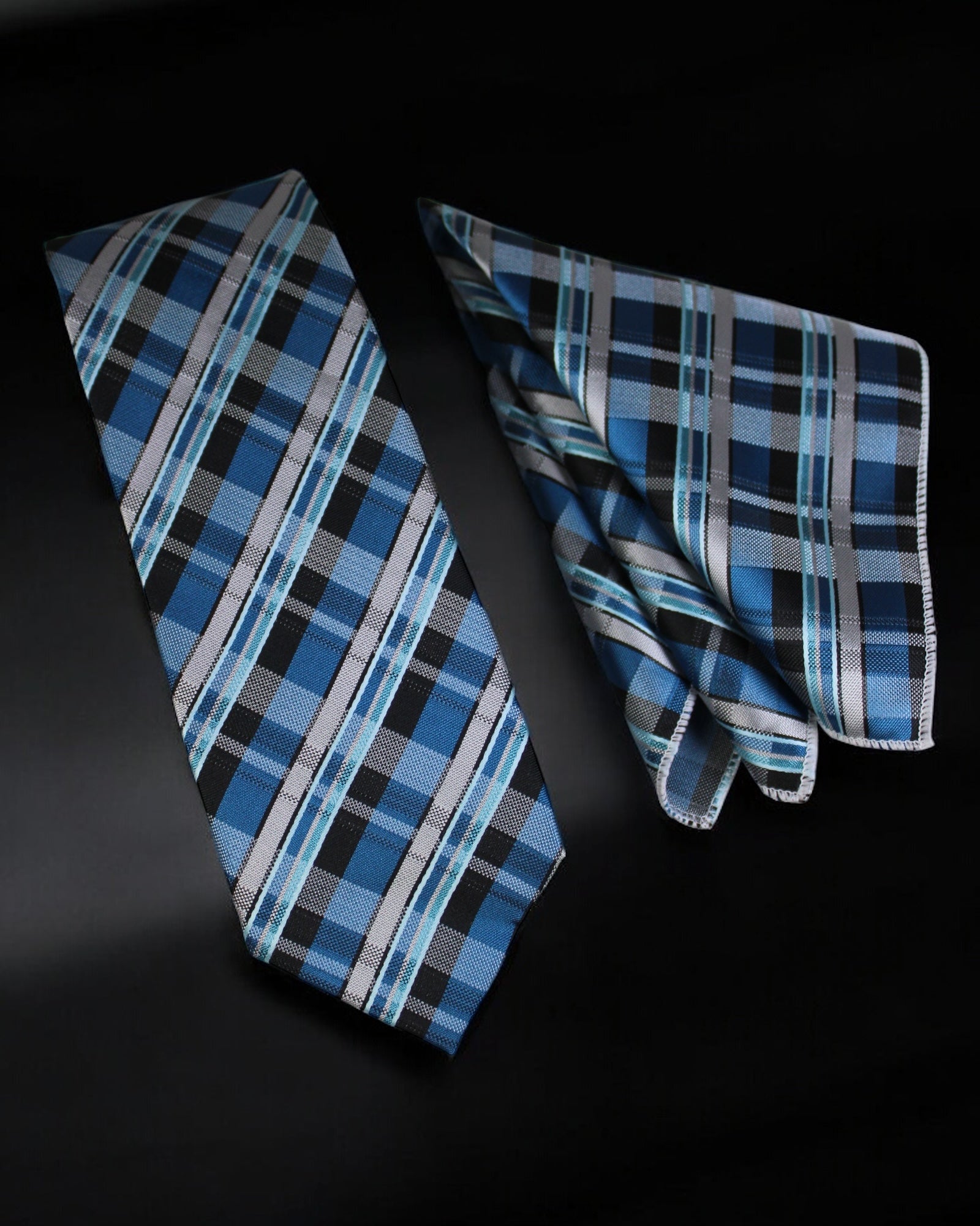 Blue plaid tie and pocket square set on a black background