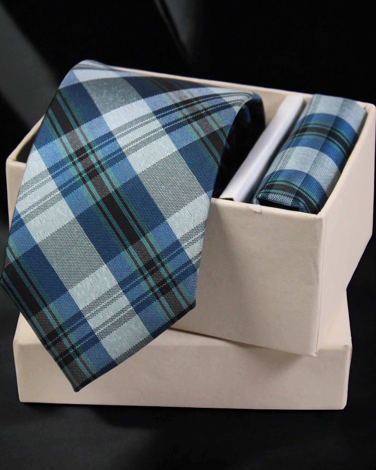 Blue plaid tie and pocket square set in a white box on a black background Tie Benon