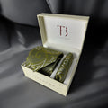 A set of pickle green paisley ties with a matching pocket square, presented in an open white box with the initial 'T' branding on the top and the brand name 'TieBenon' on the inside lid.