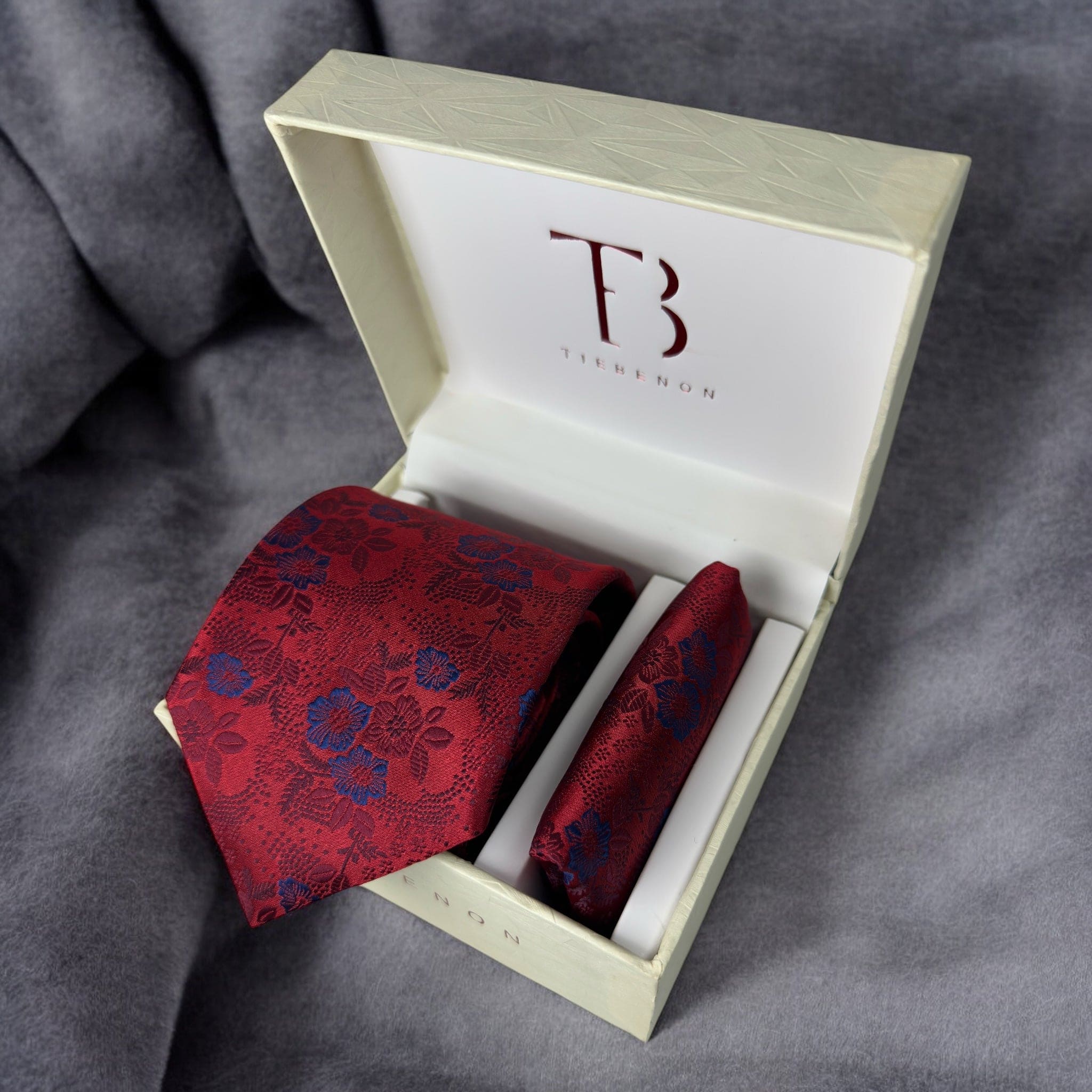 A Tie Benon branded microfiber red floral tie with a pocket square, presented in an open white box with gold interior.