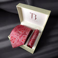 A red paisley tie with a pocket square, both laid out in a white box with a 'Tie Benon' branded cushion.
