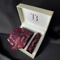 A Tie Benon branded red paisley tie with a pocket square, presented in an open wooden box with a dark interior.