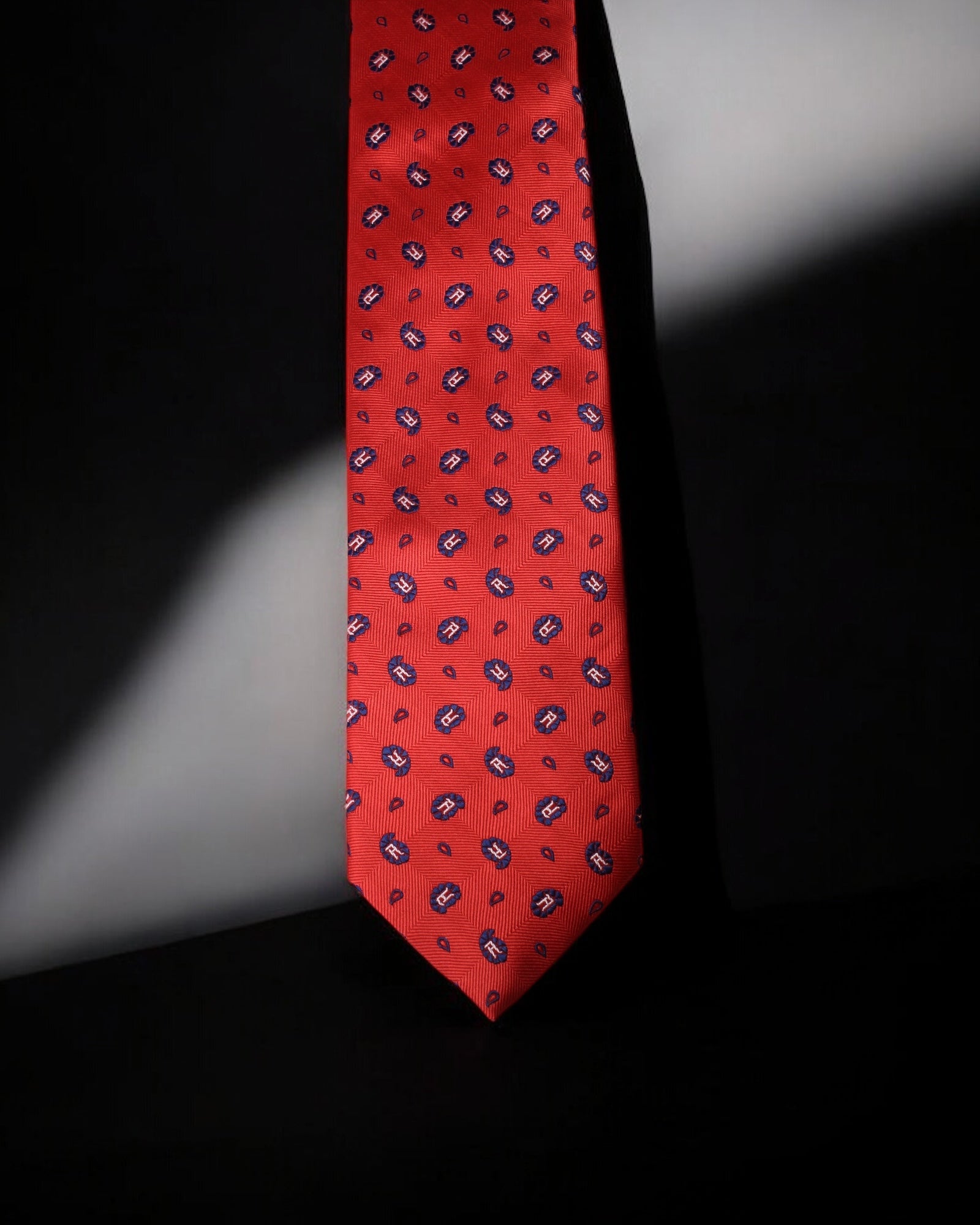 Red patterned tie on a black background