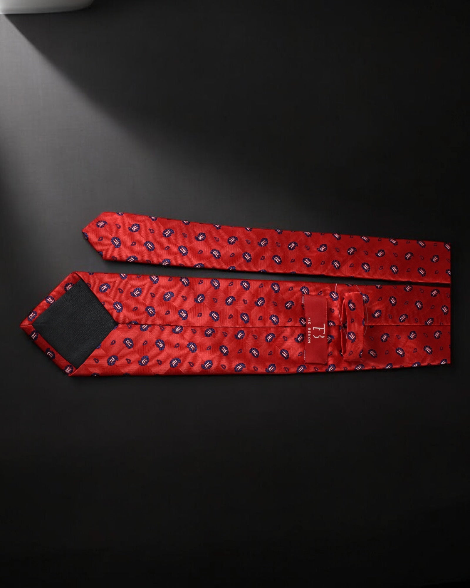 Red patterned tie on a black background