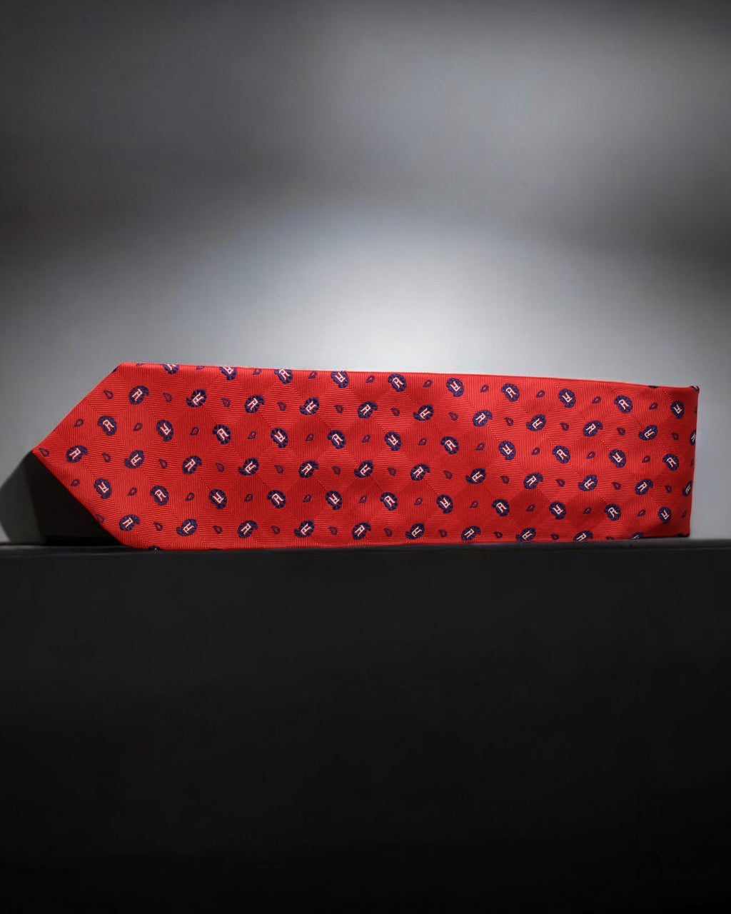 Red tie with a pattern on a black surface