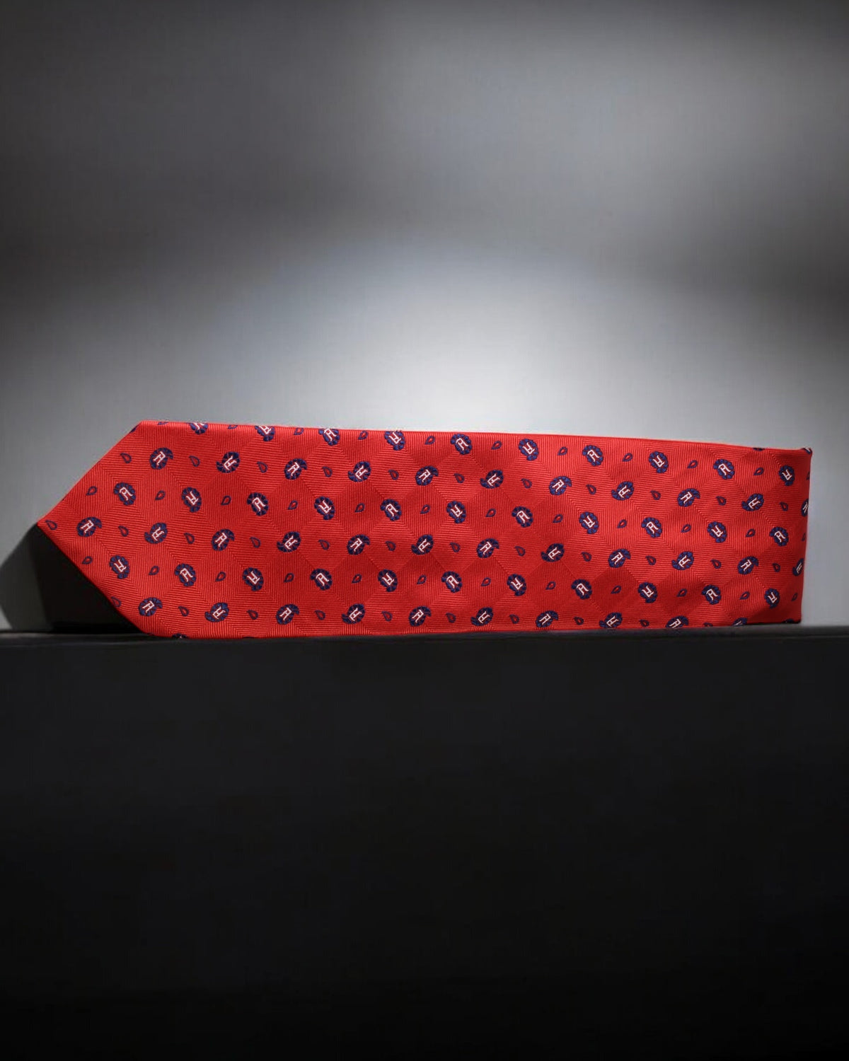 Red tie with a pattern on a black surface