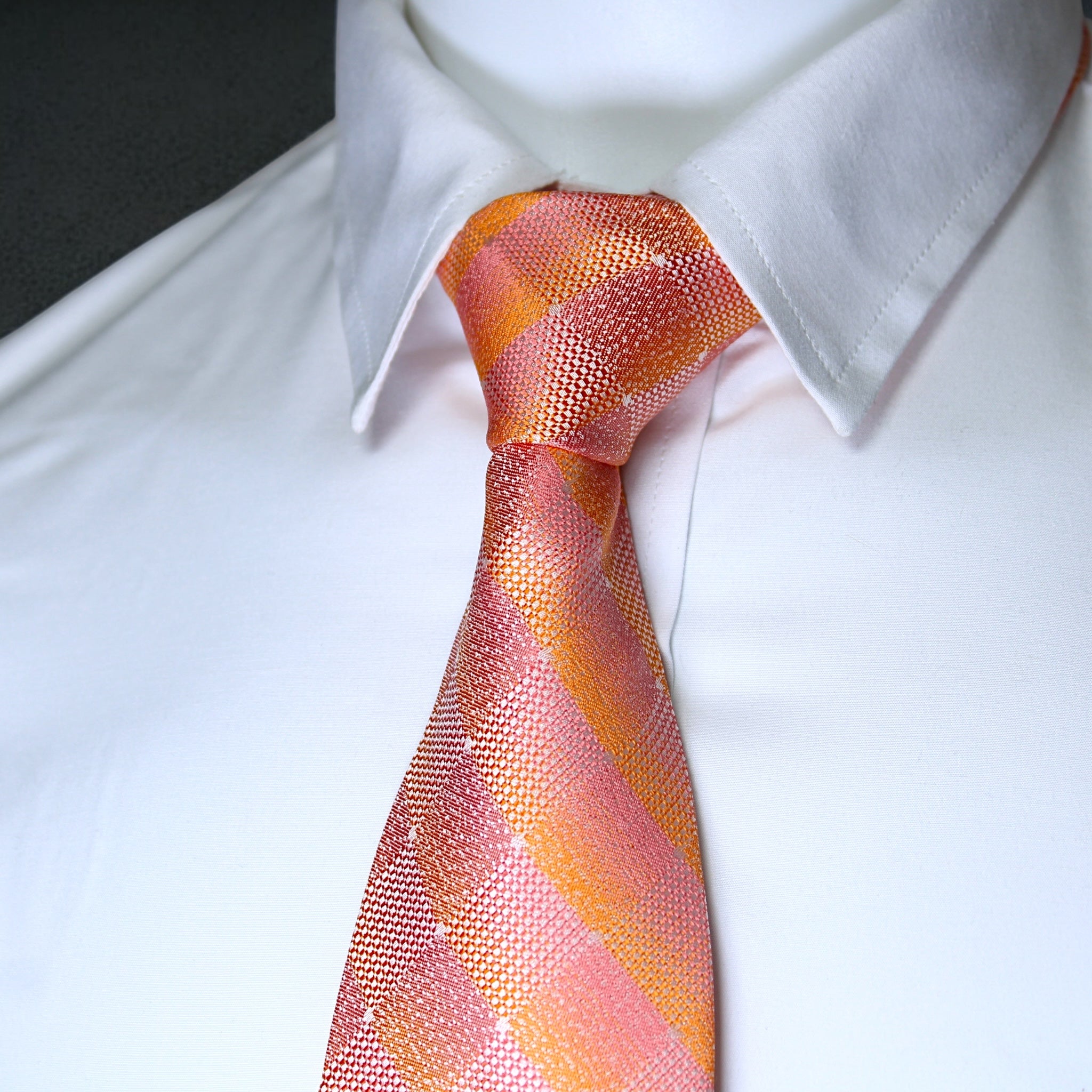 Close-up of a white shirt with a pink and orange striped tie.