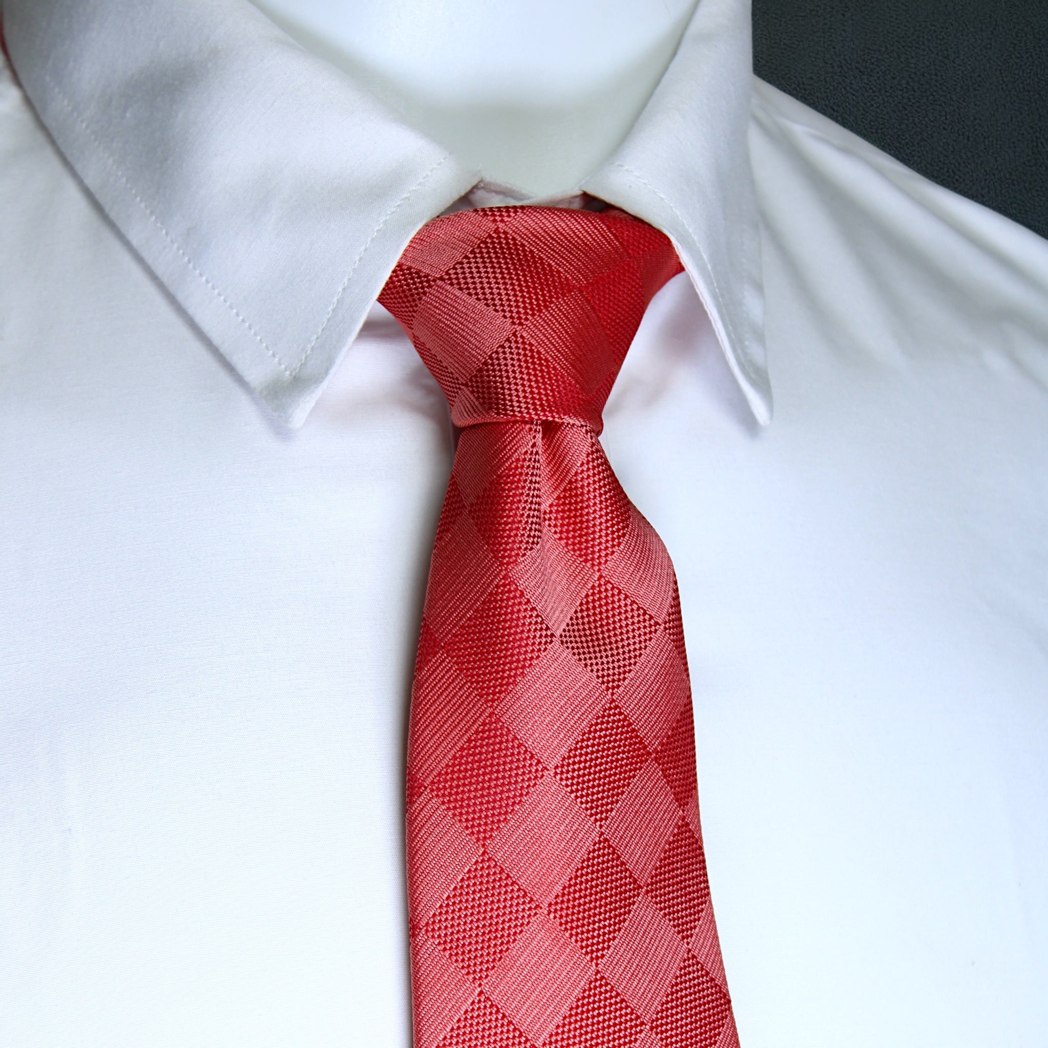 Red patterned tie on a white shirt with a blurred background