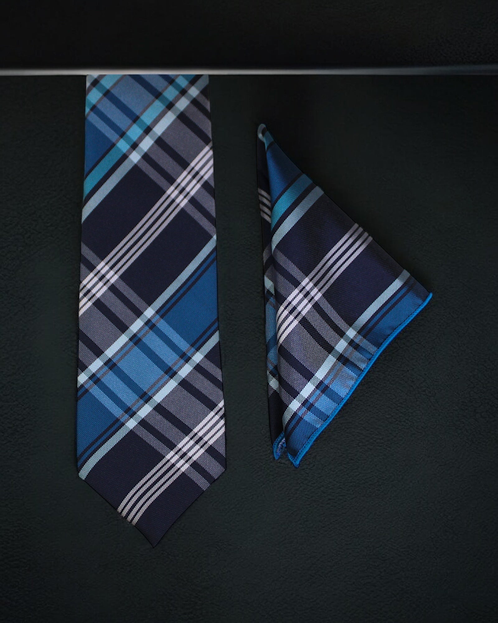 Blue plaid tie and pocket square on a black background